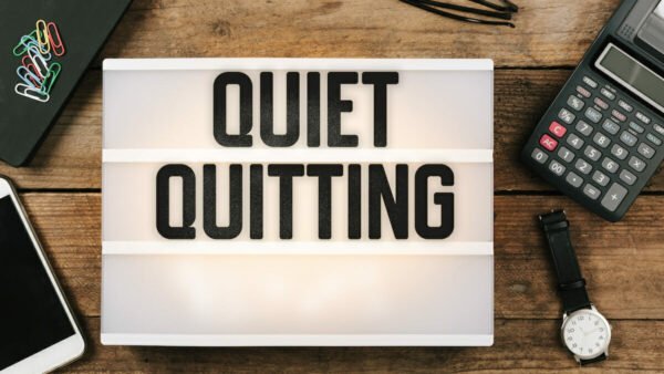 Quiet Quitting headline title in vintage style light box on office desktop, high angle birds eye view